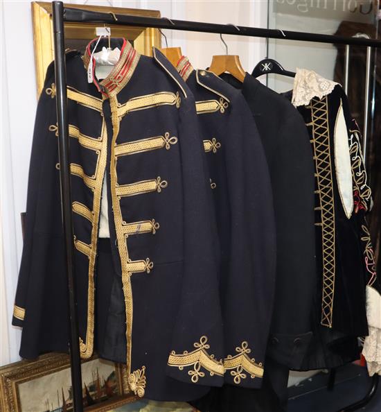 Two gold braided guards uniforms, another and a black velvet theatrical costume